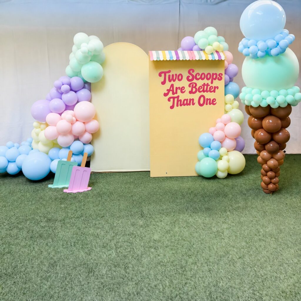 "Two Scoops Are Better Than One" installation with a giant ice cream cone balloon sculpture, pastel balloon garlands and custom arch panels